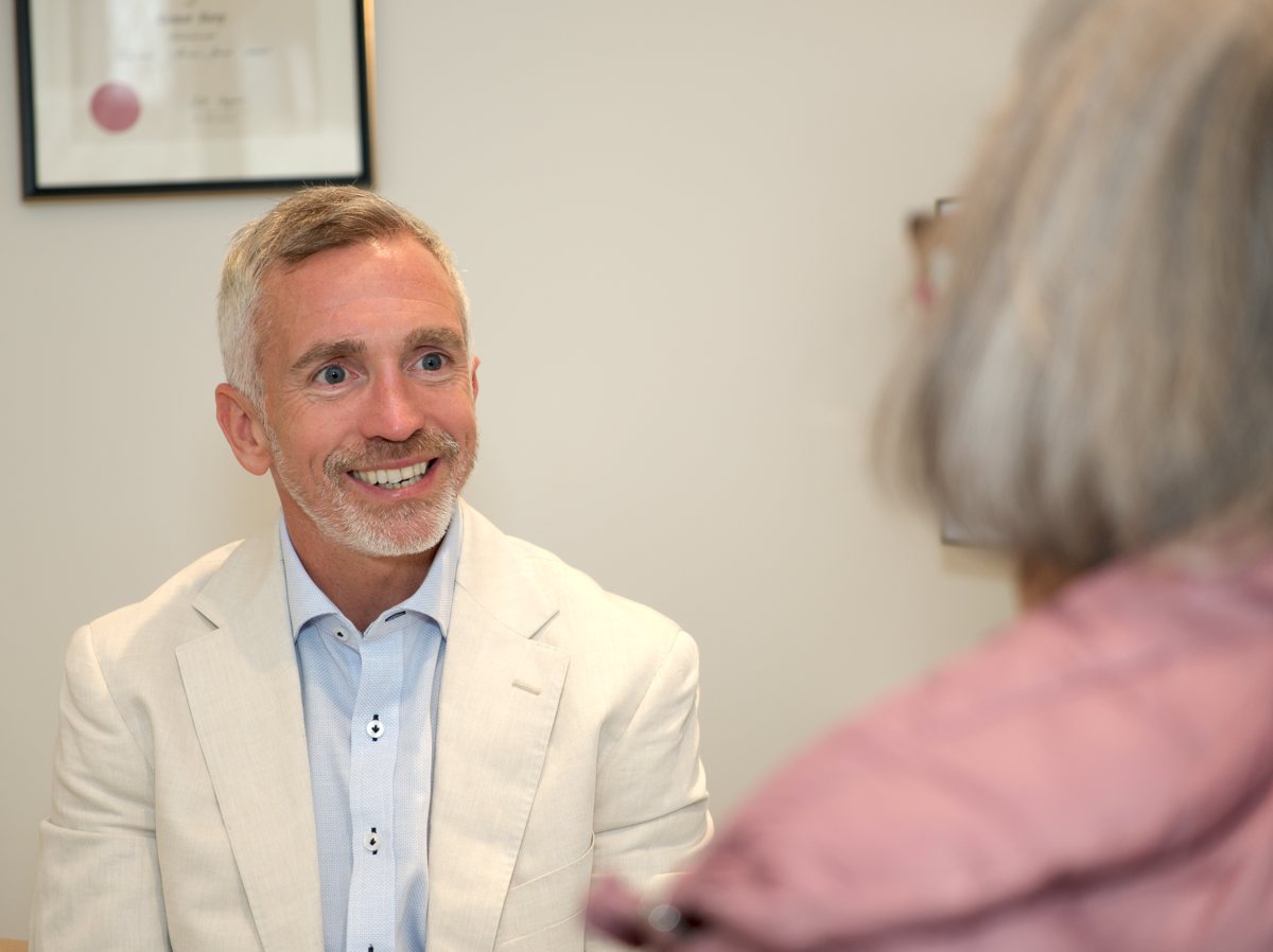 Dr Richard Barry smiling with a patient in the consulting room