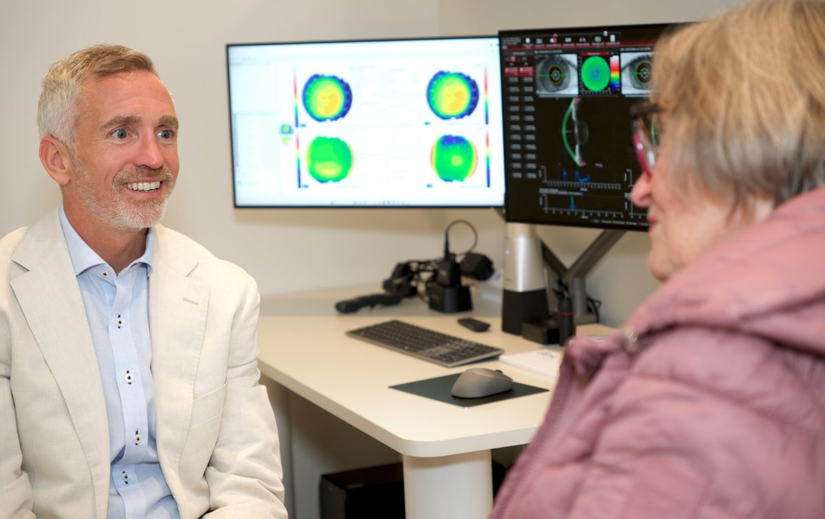 Dr Richard Barry explaining retinal scans to a patient in the consulting room